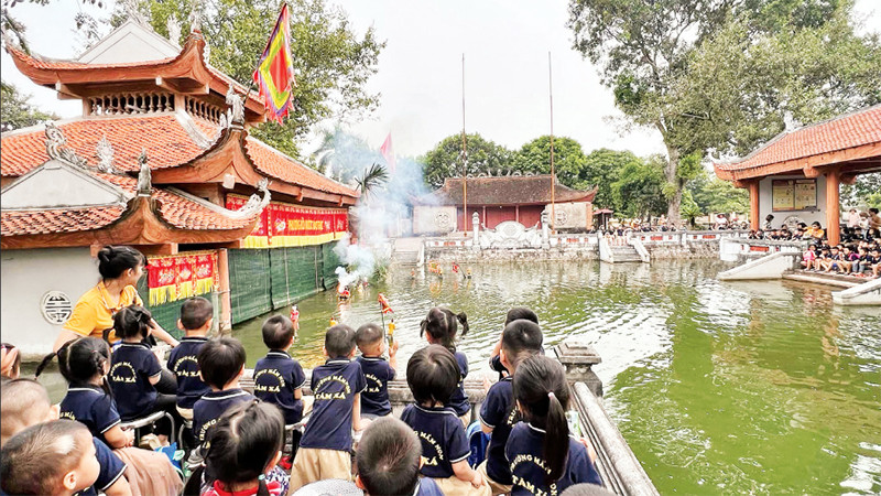 Các em nhỏ hào hứng xem các tiết mục rối nước tại làng rối Đào Thục.