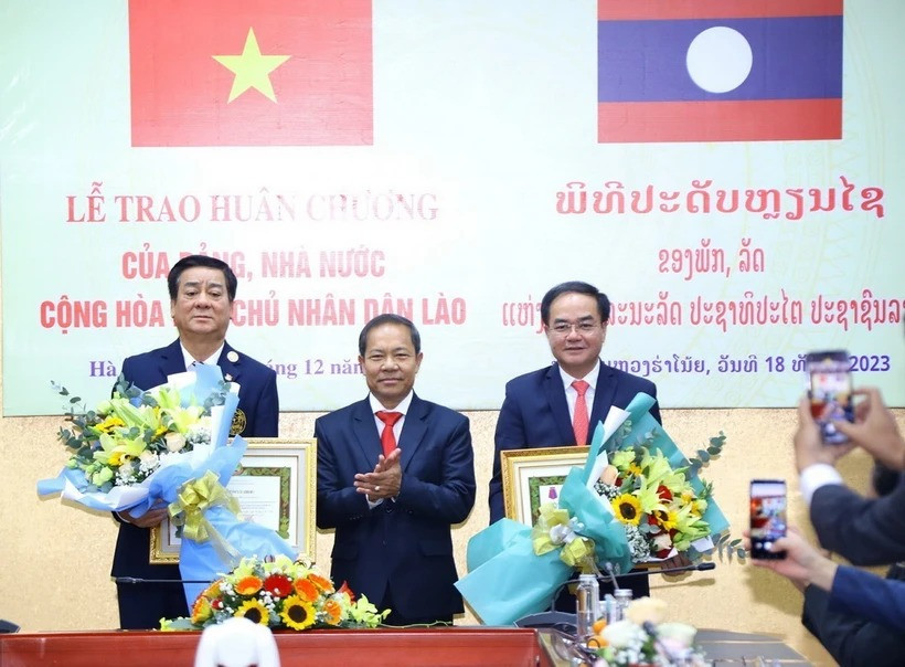 Ông Khamlay Sipraseuth, Ủy viên Trung ương Đảng, Phó Chủ tịch thường trực Ủy ban Trung ương Mặt trận Lào Xây dựng đất nước trao tặng Huân chương Itxala (Tự do) hạng III cho Thứ trưởng Bộ Nội vụ Vũ Chiến Thắng (bên phải) và nguyên Thứ trưởng, nguyên Phó Chủ nhiệm Ủy ban Dân tộc Hoàng Xuân Lương (bên trái). (Ảnh: Văn Điệp/TTXVN)