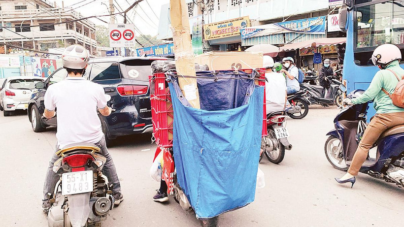 Với bao tải phía sau che kín biển kiểm soát, nhiều shipper vô tư vi phạm luật mà không bị camera giao thông phát hiện. Ảnh: Dũng Phương