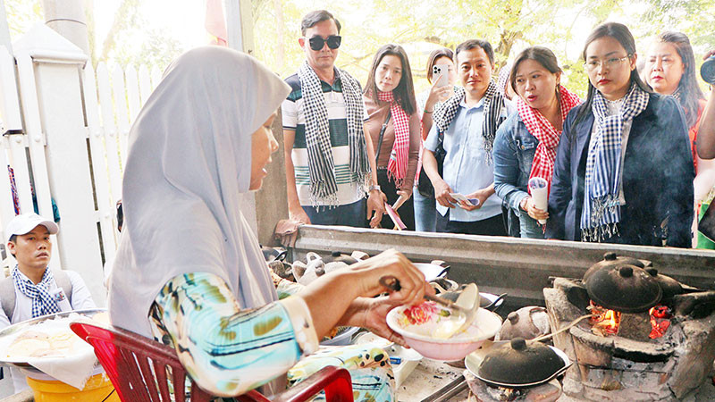 Du khách tìm hiểu cách nướng bánh bò.