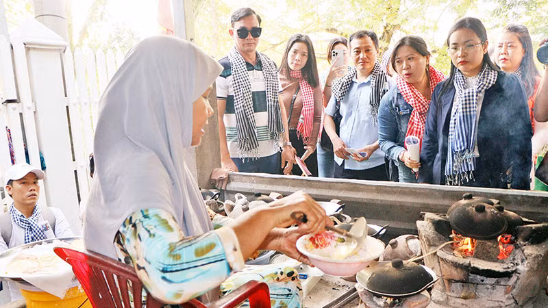 Du khách tìm hiểu cách nướng bánh bò.