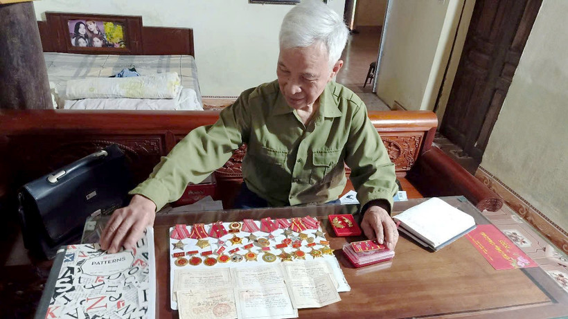 Ông Phạm Văn Ðắc xem lại những kỷ vật thời chiến.