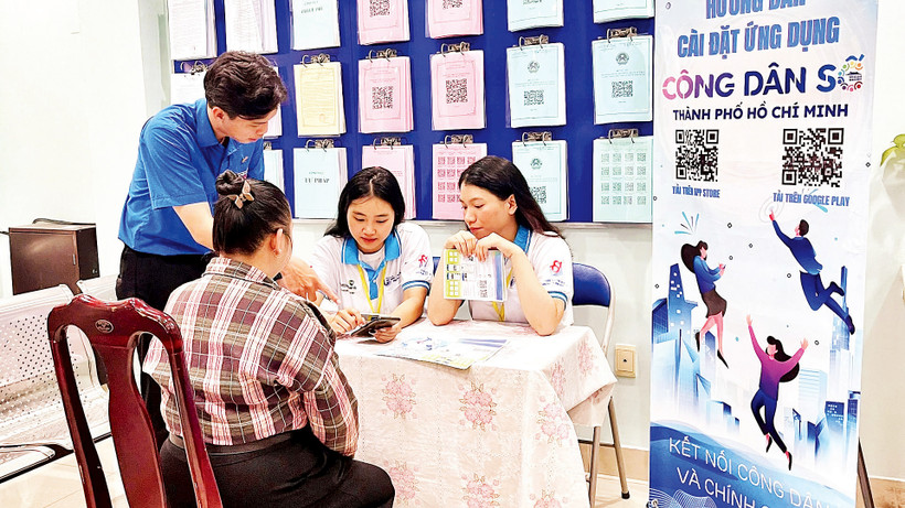 Các bạn trẻ hướng dẫn người dân Quận 1 cài đặt và sử dụng ứng dụng “Công dân số Thành phố Hồ Chí Minh”.