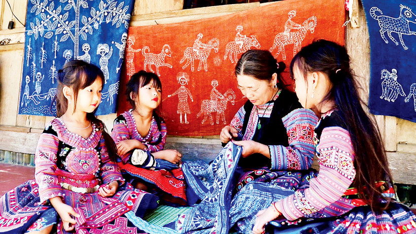 Người dân tộc H’Mông ở xã Pà Cò truyền nghề dệt thổ cẩm cho thế hệ trẻ. 
