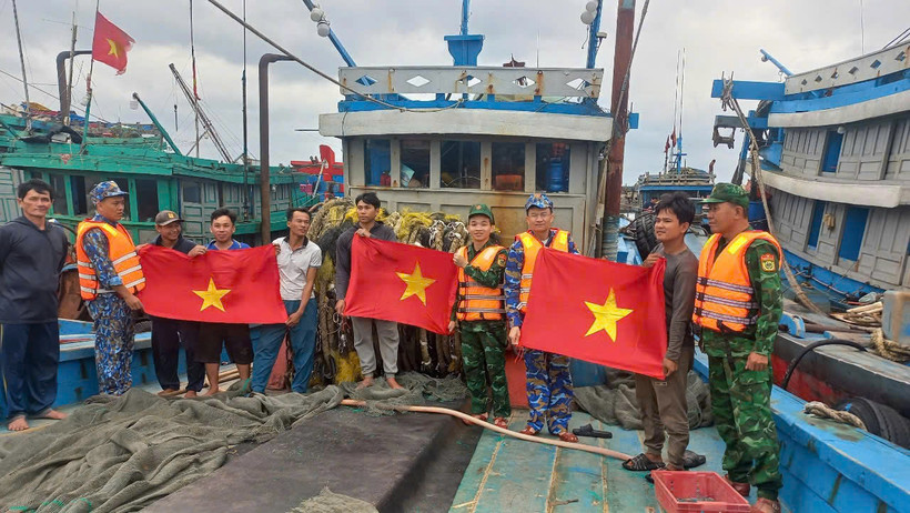 Cán bộ, chiến sĩ BĐBP thành phố Hải Phòng tặng cờ cho ngư bám biển. 