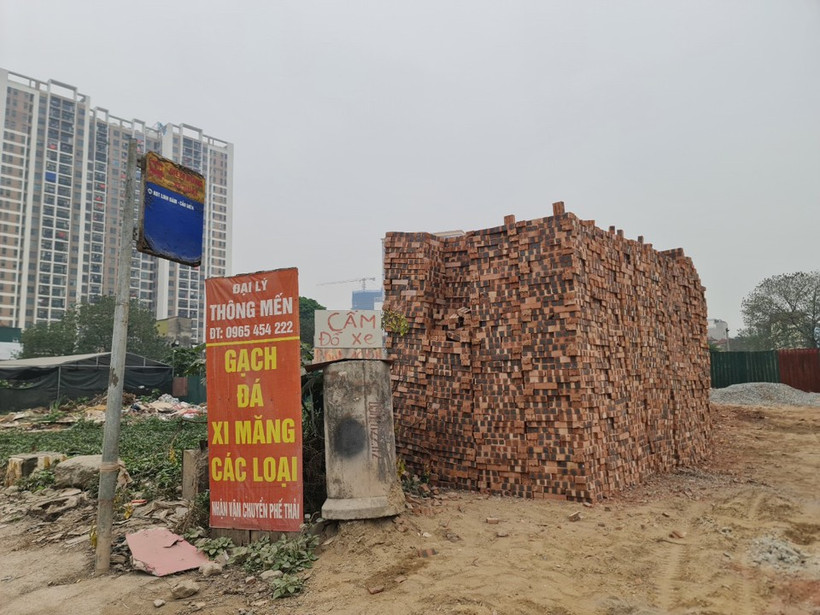 Khu vực đứng chờ xe buýt cũng bị lấn chiếm để bày, bán vật liệu xây dựng.