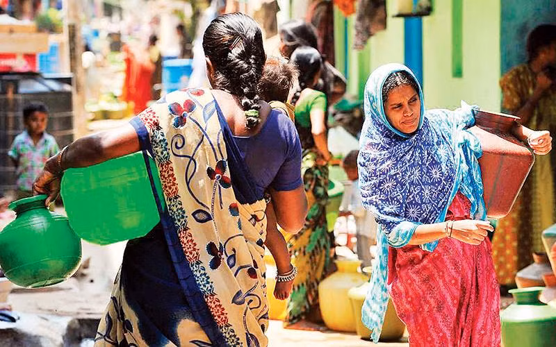 Những phụ nữ mang nước sạch từ vòi công cộng về nhà ở Bengaluru. Ảnh | Manjunath Kiran/ AFP