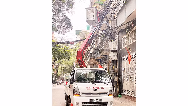 Công nhân Công ty Chiếu sáng đô thị lắp đặt hệ thống chiếu sáng thông minh tại quận Ba Đình. (Ảnh Khánh Sơn)