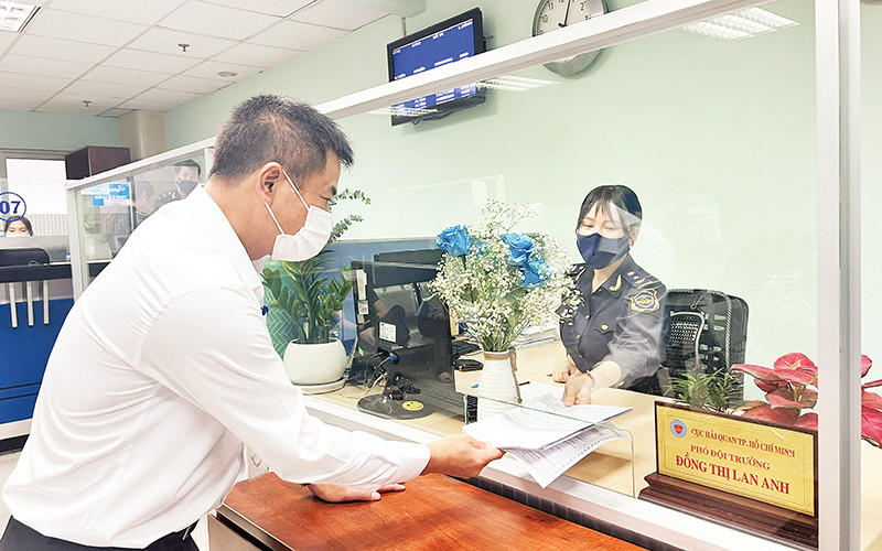 Cán bộ Hải quan Thành phố Hồ Chí Minh hướng dẫn thủ tục khai thuế cho doanh nghiệp. (Ảnh Cục Hải quan thành phố)