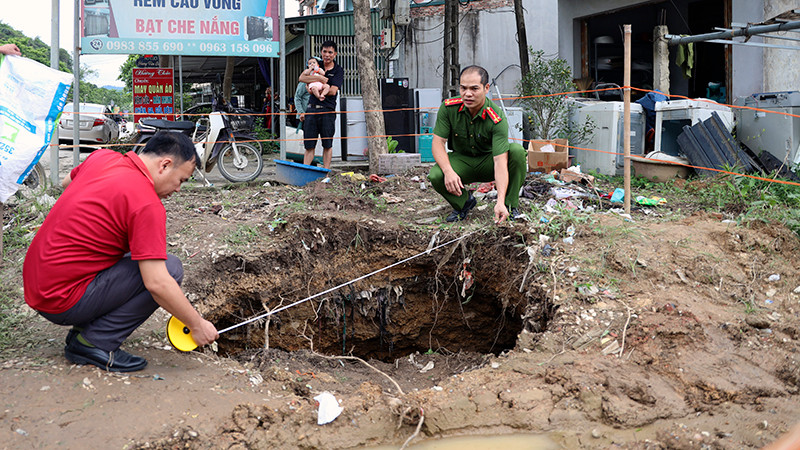 Lực lượng Công an xã Tân Thanh kiểm tra độ rộng của hố sụt lún.