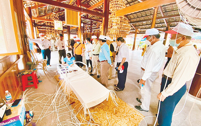 Du khách xem một công đoạn thêu truyền thống.