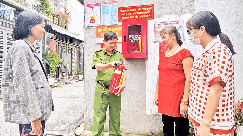 Công an phường Tân Chánh Hiệp hướng dẫn người dân sử dụng bình chữa cháy trong quá trình triển khai mô hình “Tổ liên gia an toàn phòng cháy chữa cháy”. 