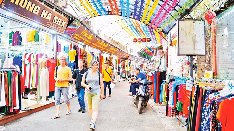 Khách du lịch tham quan quầy hàng trong làng dệt lụa Vạn Phúc.