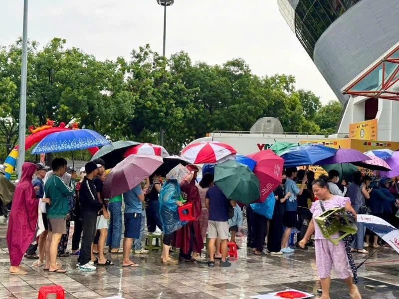 Khán giả đội mưa mua vé xem thi đấu. z6751973044978-e25f0041c9a2a8455498f1700cc6891d.jpg