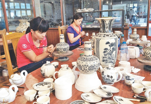 Vẽ trang trí trên gốm hoa lam tại xưởng sản xuất của Công ty CP gốm Chu Đậu.