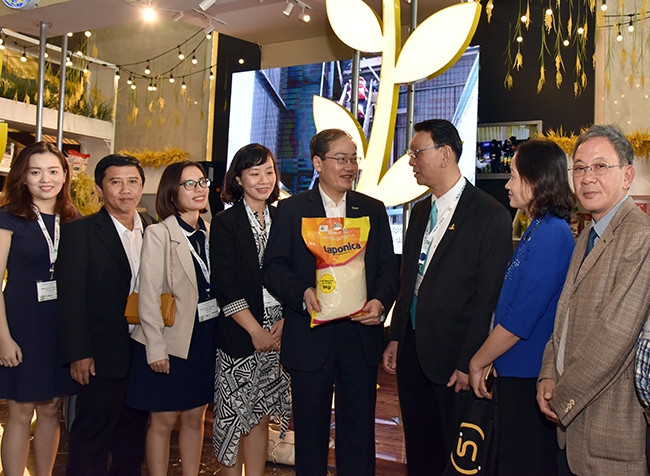 Lãnh đạo Tổng công ty Thương mại Hà Nội giới thiệu mặt hàng gạo giống Nhật trồng tại Việt Nam với khách hàng nước ngoài tại Hội nghị Gạo thế giới. Ảnh: Duy Linh