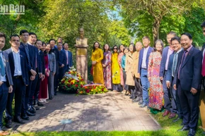 Các đại biểu chụp ảnh lưu niệm bên tượng Chủ tịch Hồ Chí Minh. (Ảnh: KHẢI HOÀN)