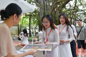 Các bạn đọc trẻ tuổi xếp hàng dài chờ nhận tặng phụ san số Báo Nhân Dân đặc biệt phát hành ngày 7/5/2024. (Ảnh: THẾ ĐẠI)