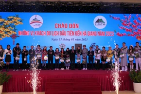 Lãnh đạo tỉnh Hà Giang tặng hoa và quà chúc mừng những vị khách đầu tiên.