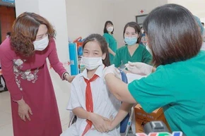 Thứ trưởng Nguyễn Thị Liên Hương động viên các em học sinh tham gia tiêm chủng.