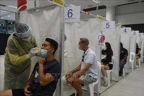 Nhân viên y tế lấy mẫu xét nghiệm Covid-19 cho người dân tại Singapore. (Ảnh tư liệu: THX/TTXVN)