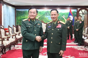 Thượng tướng Hoàng Xuân Chiến chào Bộ trưởng Quốc phòng Lào Khamlieng Outhakaysone. (Ảnh: TRỊNH DŨNG)