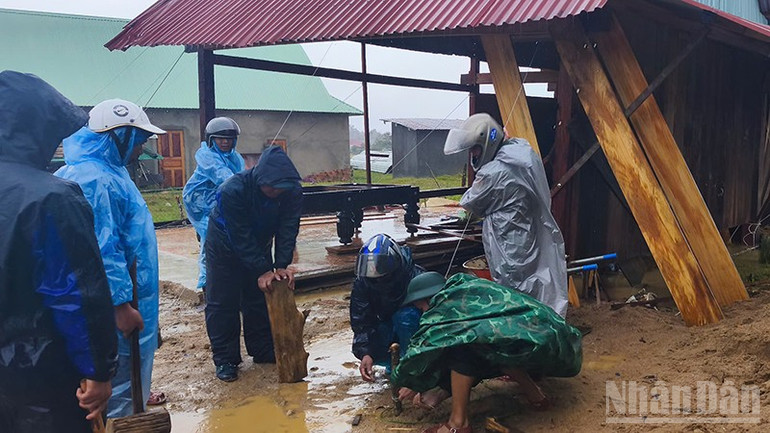 Các lực lượng chức năng hỗ trợ người dân gia cố mái nhà. ndo_br_4.jpg