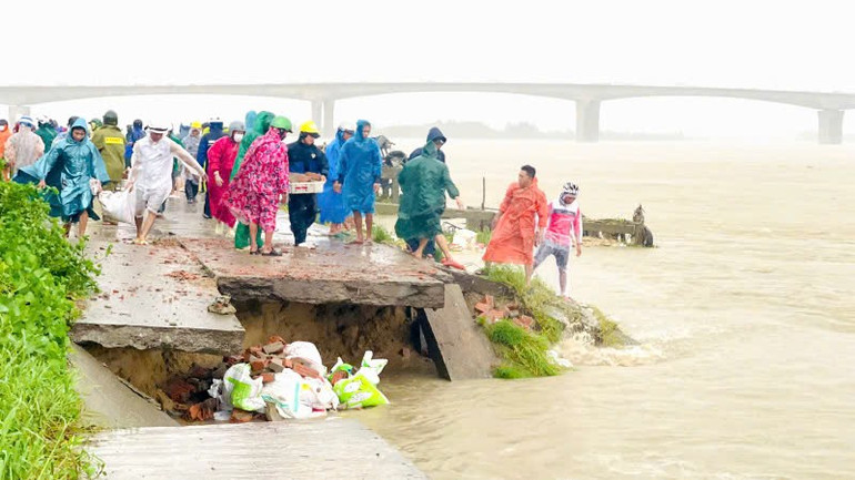 Hàng trăm người từ các lực lượng trực chiến Sư đoàn 315, Công an, dân quân và người dân địa phương khẩn trương gia cố tạm thời các vị trí sạt lở bờ kè. z7167593939676-2e5a305d0dd59460745e3190359c34d6.jpg