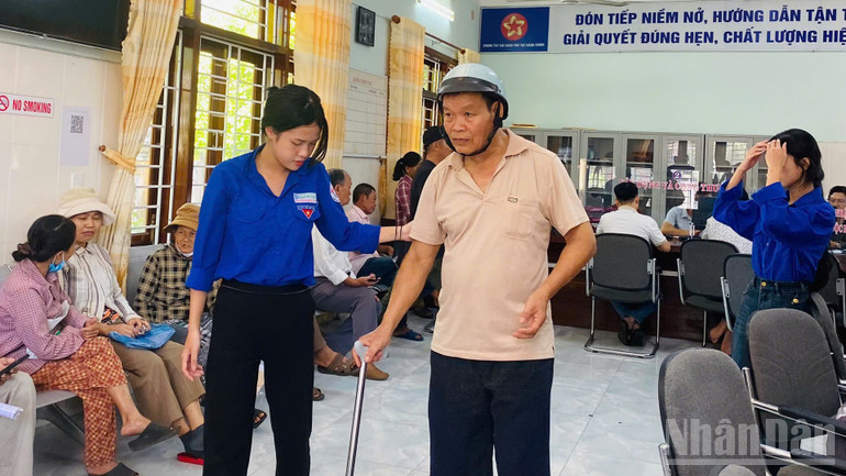 Đoàn viên Trần Thị Mai Hậu hỗ trợ người dân lớn tuổi đến thực hiện thủ tục hành chính. ndo_br_11.jpg