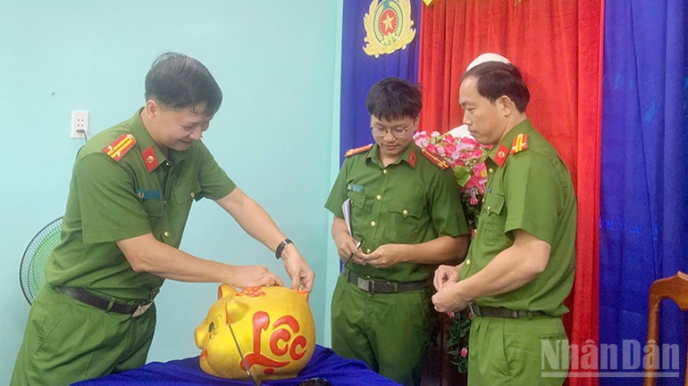 Trung tá Nguyễn Hoàng Cầu, Trưởng Công an xã Phú Ninh cùng cán bộ, chiến sĩ thực hiện phong trào “Nuôi heo đất”. ndo_br_6.jpg