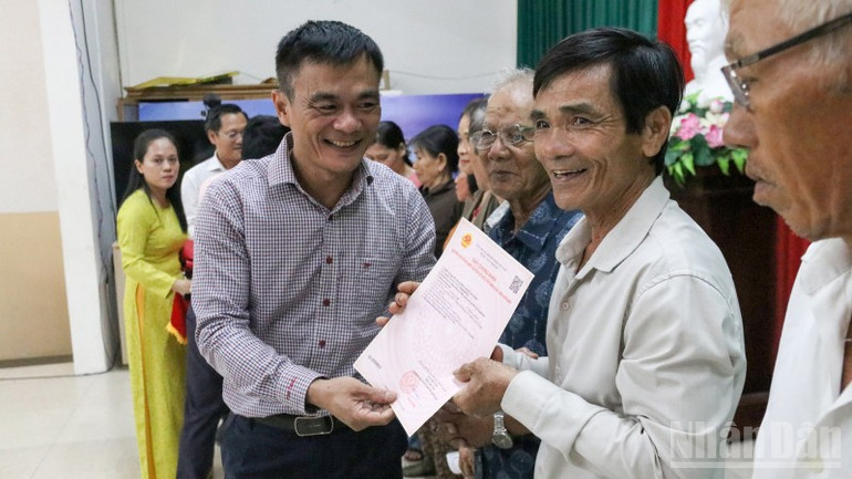 Bí thư Đảng ủy phường Hương Trà Phạm Hoàng Đức trao giấy chứng nhận quyền sử dụng đất cho người dân. ndo_br_img-8157.jpg
