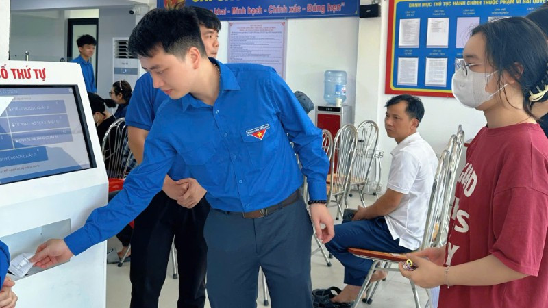 Người dân lấy số thứ tự tại Điểm phục vụ hành chính công xã Ô Diên (Hà Nội). 