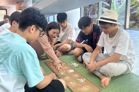Các em nhỏ trải nghiệm trò chơi ô ăn quan. (Ảnh: Bảo tàng cung cấp)