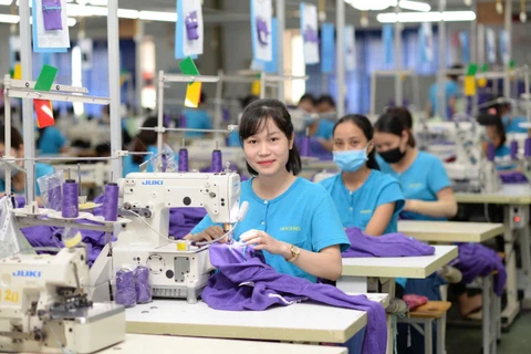 Công nhân nữ làm việc hứng khởi tại cơ sở sản xuất của Tổng công ty Cổ phần Dệt may Hà Nội (Hanosimex).