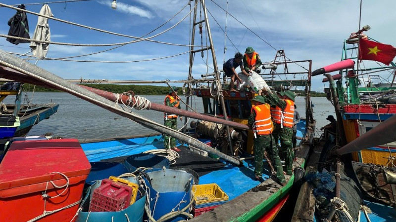 Cán bộ, chiến sĩ Đồn Biên phòng Diễn Thành hướng dẫn, giúp đỡ ngư dân neo đậu tàu thuyền phòng chống bão số 5.