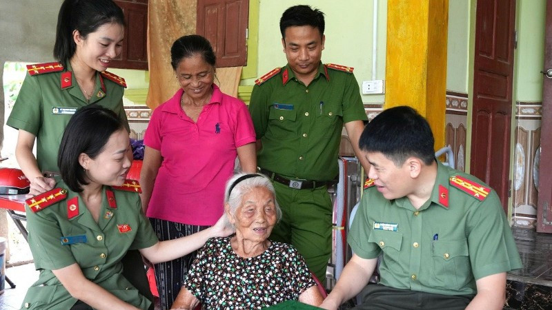 Đại tá Trần Hồng Quang, Phó Giám đốc Công an tỉnh Nghệ An ân cần thăm hỏi sức khỏe Mẹ Việt Nam Anh hùng Nguyễn Thị Năm. (Ảnh: CÔNG AN NGHỆ AN)