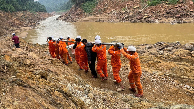 Công nhân vận chuyển máy móc, thiết bị vượt ghềnh đá để xuống thuyền, sau đó vượt qua quãng sông dài với nhiều đoạn thác nguy hiểm để đến được bản.