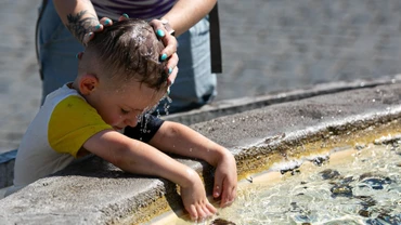 Bà mẹ làm mát cho con nhỏ khi nắng nóng bao trùm thủ đô Rome, Italia ngày 14/7/2024. (Ảnh: THX/TTXVN)