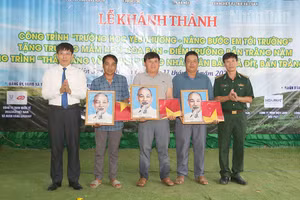 Lãnh đạo Ban Chỉ huy Bộ đội Biên phòng tỉnh Sơn La và xã Yên Sơn tặng ảnh Bác Hồ và cờ Tổ quốc cho các bản.