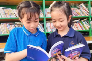 Các em học sinh rất hào hứng khi được tặng sách thiếu nhi “Bí mật quả cầu tím”.
