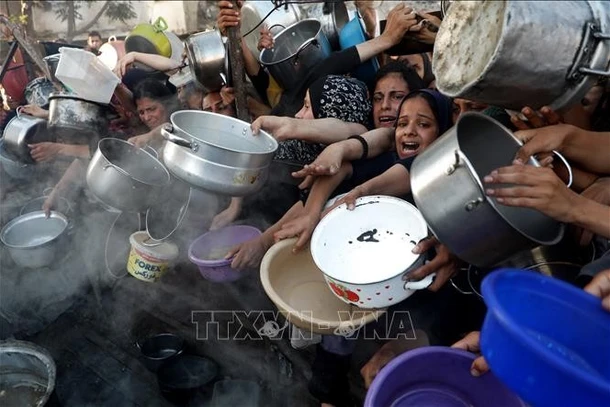 Người dân Palestine chờ được phát thực phẩm cứu trợ tại Gaza. (Ảnh: THX/TTXVN)