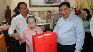 Phó Thủ tướng Chính phủ Nguyễn Chí Dũng thăm hỏi, tặng quà cho bà Hồ Thị Lượm, Anh hùng lao động trong thời kỳ kháng chiến. (Ảnh: NGUYỄN TRUNG)