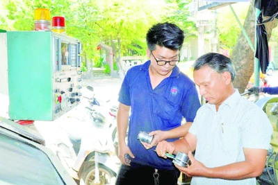 Ông Lê Thêm (bên phải) cùng cộng sự nghiên cứu sáng chế sản phẩm mới.