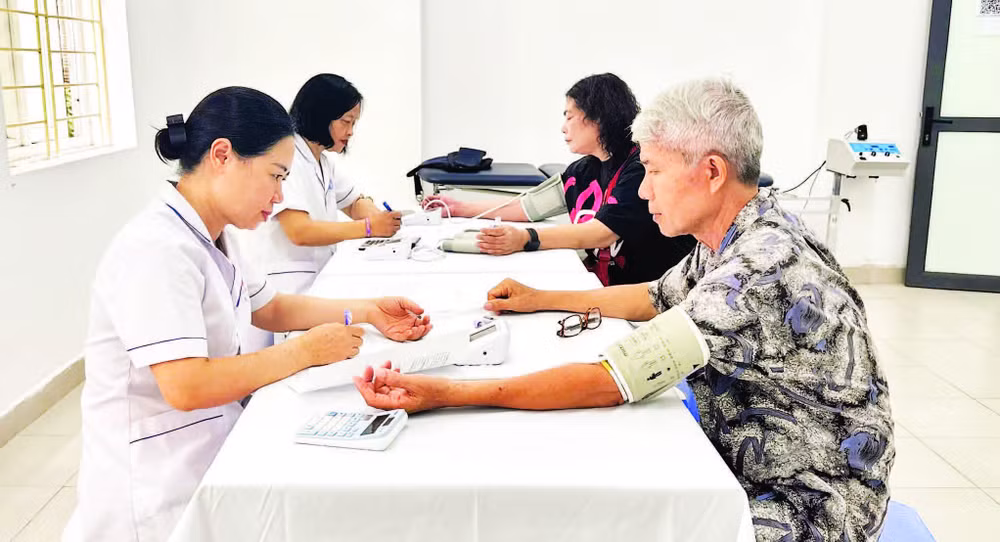 Các bác sĩ, nhân viên y tế Trạm Y tế phường Khương Đình khám sức khỏe định kỳ cho người dân trên địa bàn.
