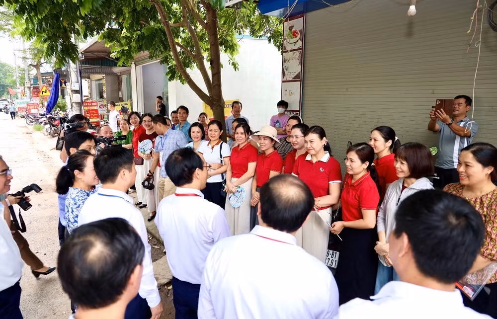 Bộ trưởng Giáo dục và Đào tạo Hoàng Minh Sơn trò chuyện với phụ huynh và giáo viên bên ngoài điểm thi Trường trung học phổ thông Kim Động (Hưng Yên) trước giờ làm bài môn Ngữ văn.