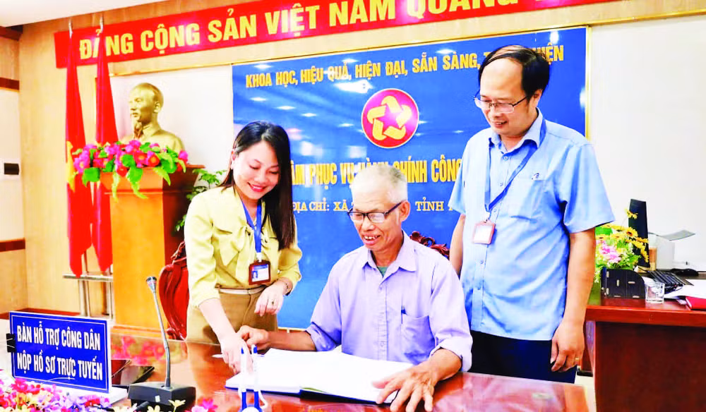 Cán bộ Trung tâm Phục vụ hành chính công xã Tam Nông hỗ trợ người dân thực hiện các thủ tục hành chính.