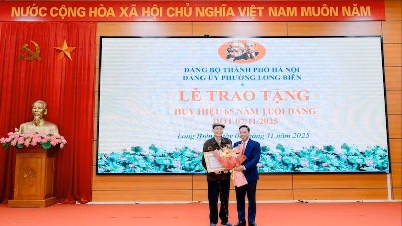Bí thư Đảng ủy phường Long Biên trao Huy hiệu Đảng tặng đảng viên.