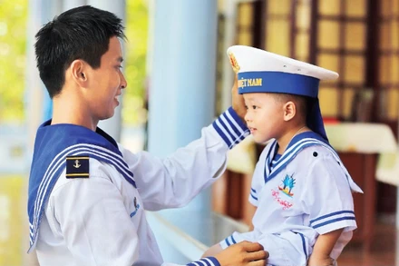 Chiến sĩ hải quân cùng em nhỏ trên đặc khu Trường Sa. (Ảnh: THẾ ĐẠI)