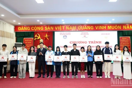 Đồng chí Phan Văn Hùng, Phó Tổng Biên tập Báo Nhân Dân và đồng chí Lê Thị Thanh Trà, Phó Chủ tịch Hội đồng nhân dân tỉnh Tuyên Quang trao học bổng cho các sinh viên nghèo vượt khó.