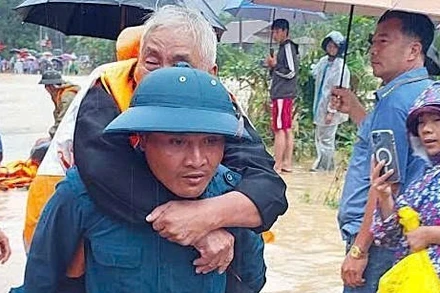 Lực lượng dân quân xã Yang Mao vượt lũ đưa người dân thôn Ea Hăn đến nơi an toàn.